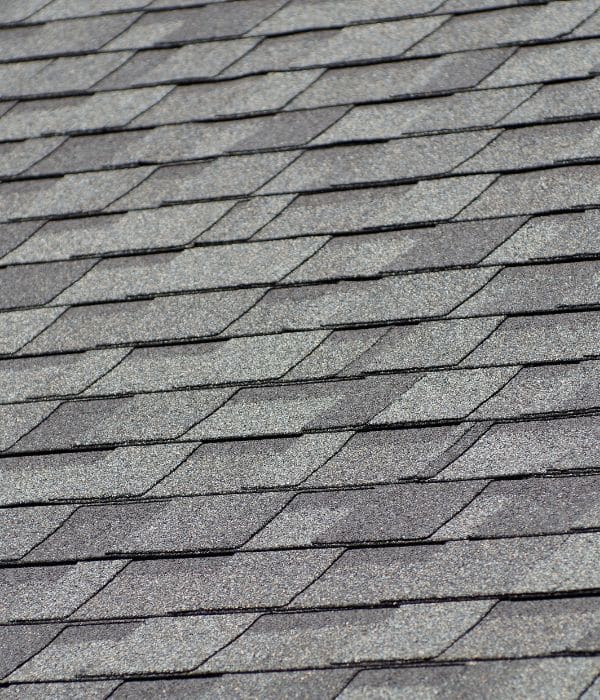 Close-up view of gray asphalt shingles on a roof, arranged diagonally—perfect for homes seeking quality and reliable roofing warranties.
