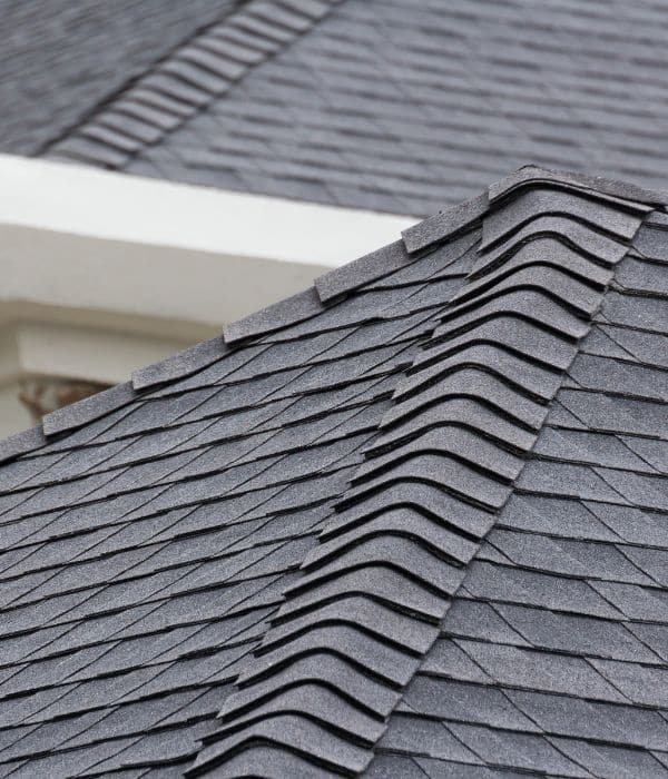 Close-up of a grey asphalt shingle roof, neatly arranged by expert Roofing Services on residential rooftops.