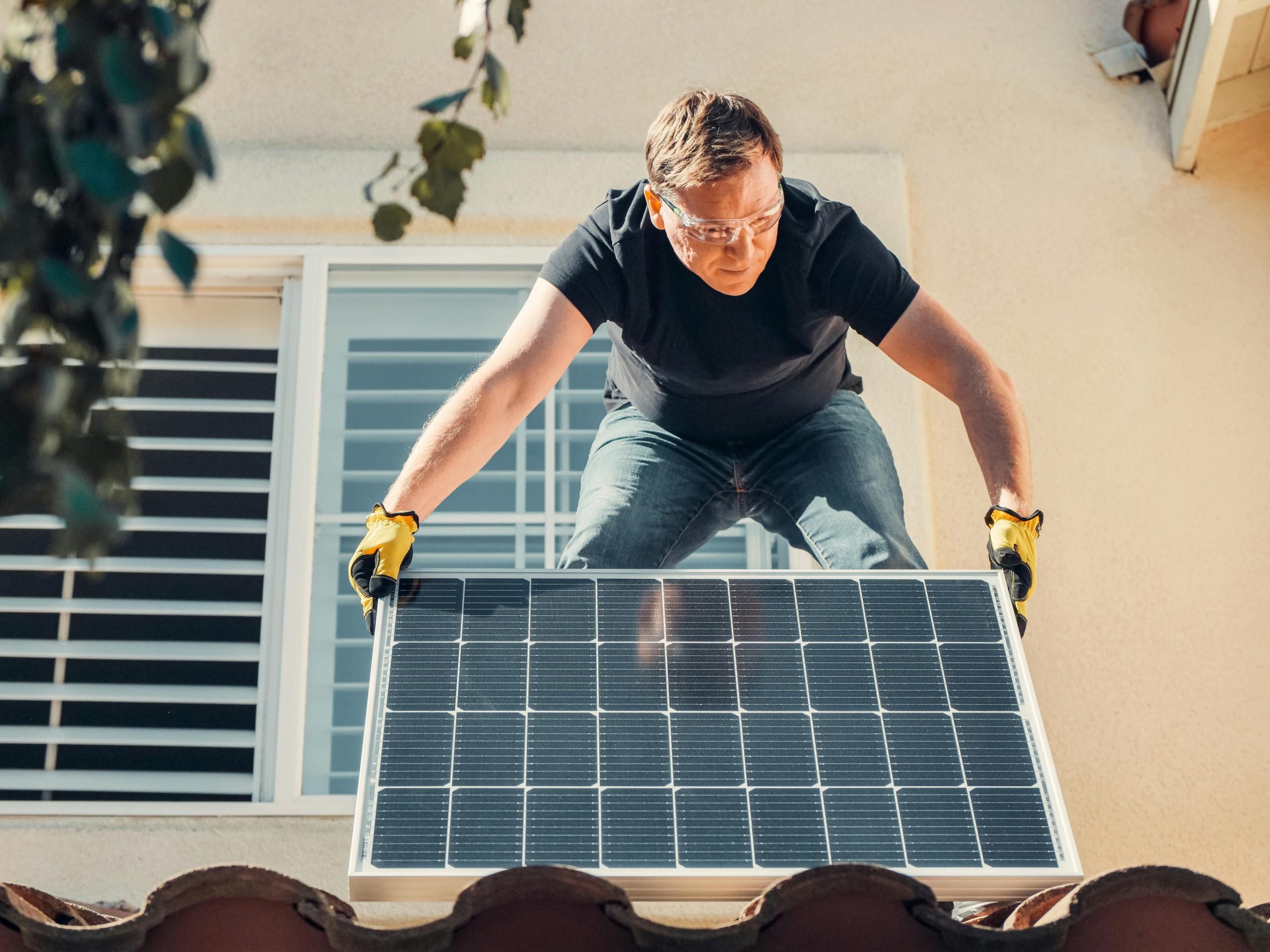 Man installing a solar panel on a roof